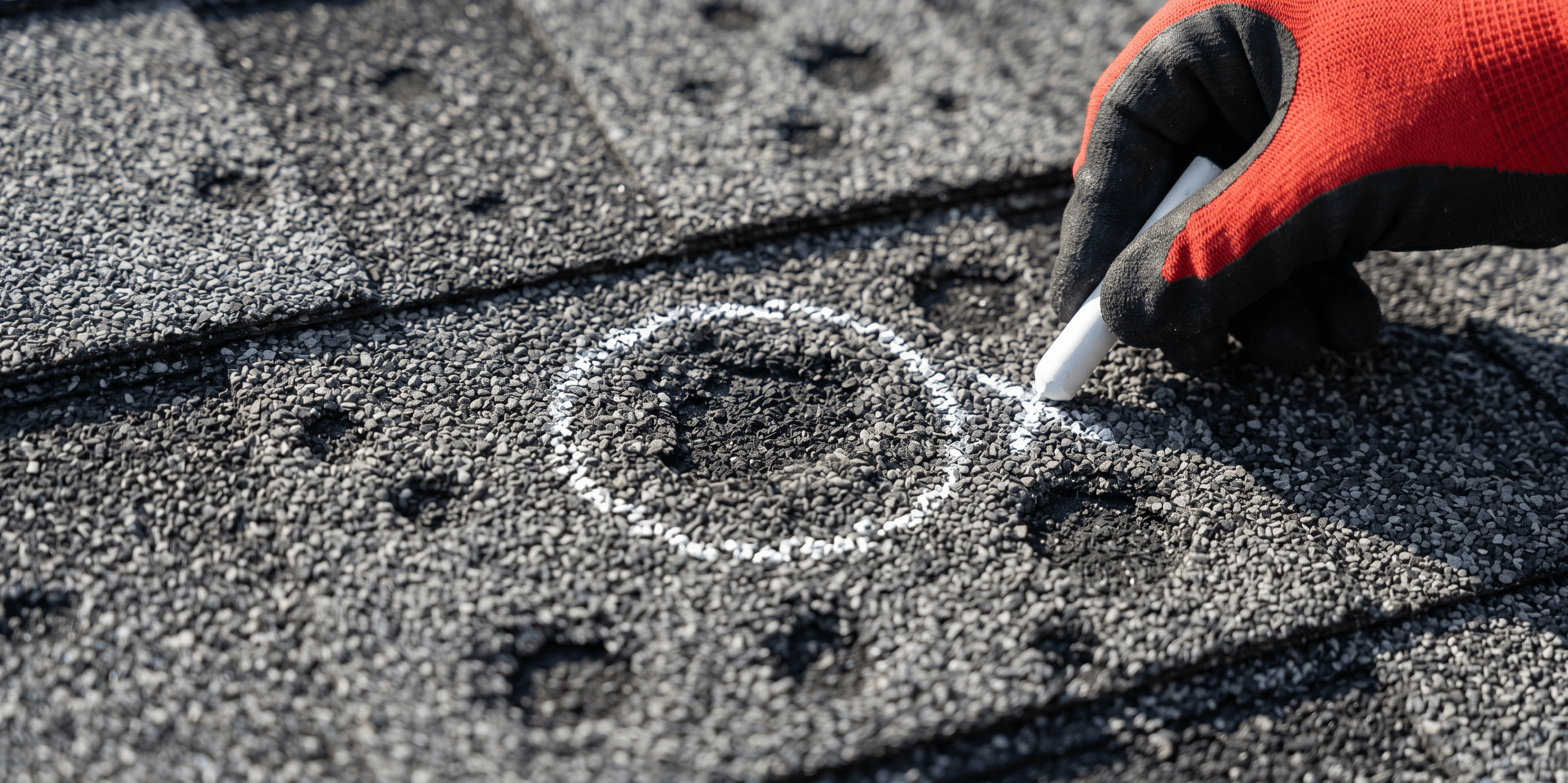 Roofer chalking hail strikes on a Calgary asphalt-shingle roof